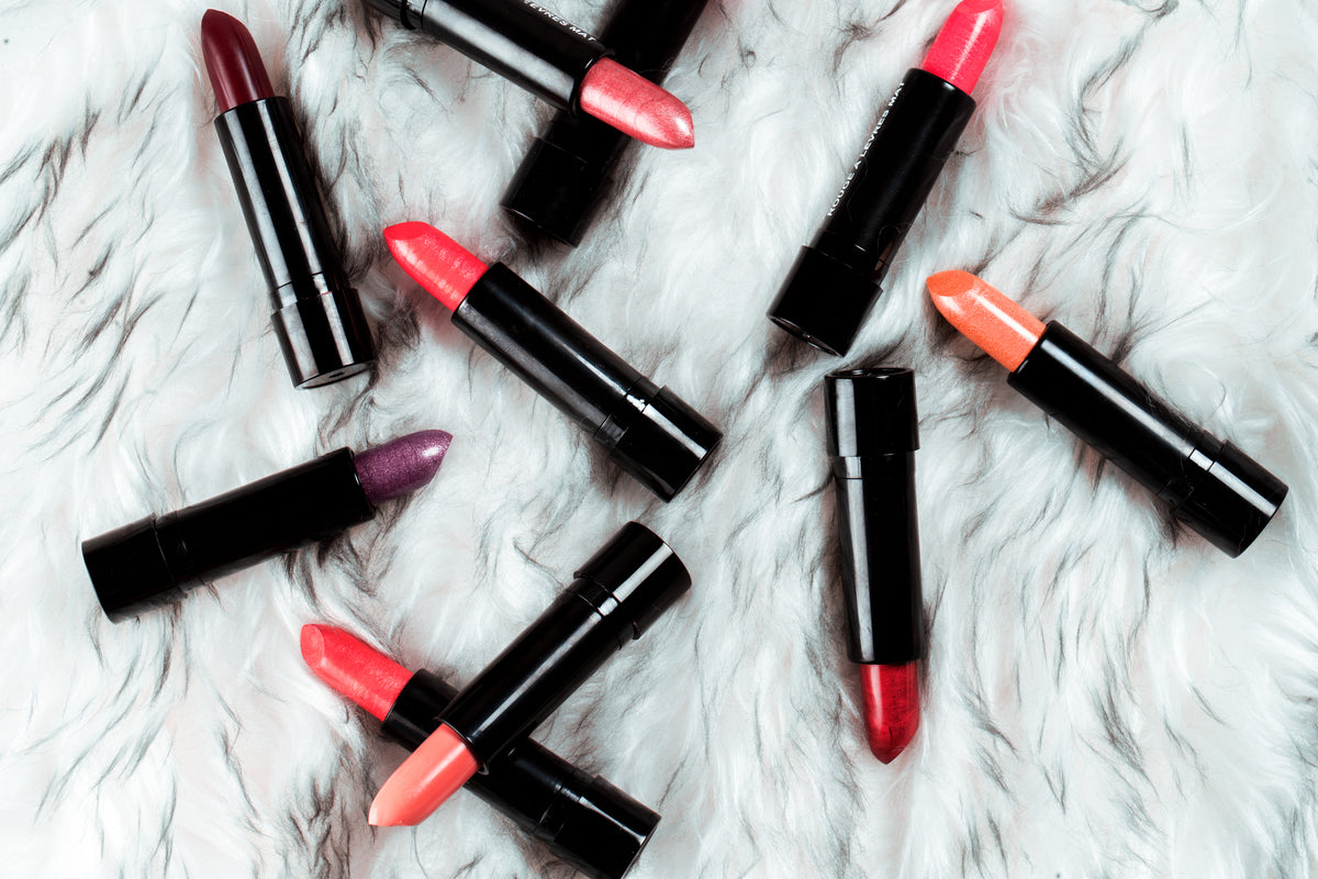 A flat lay of lipsticks in reds, pinks and corals