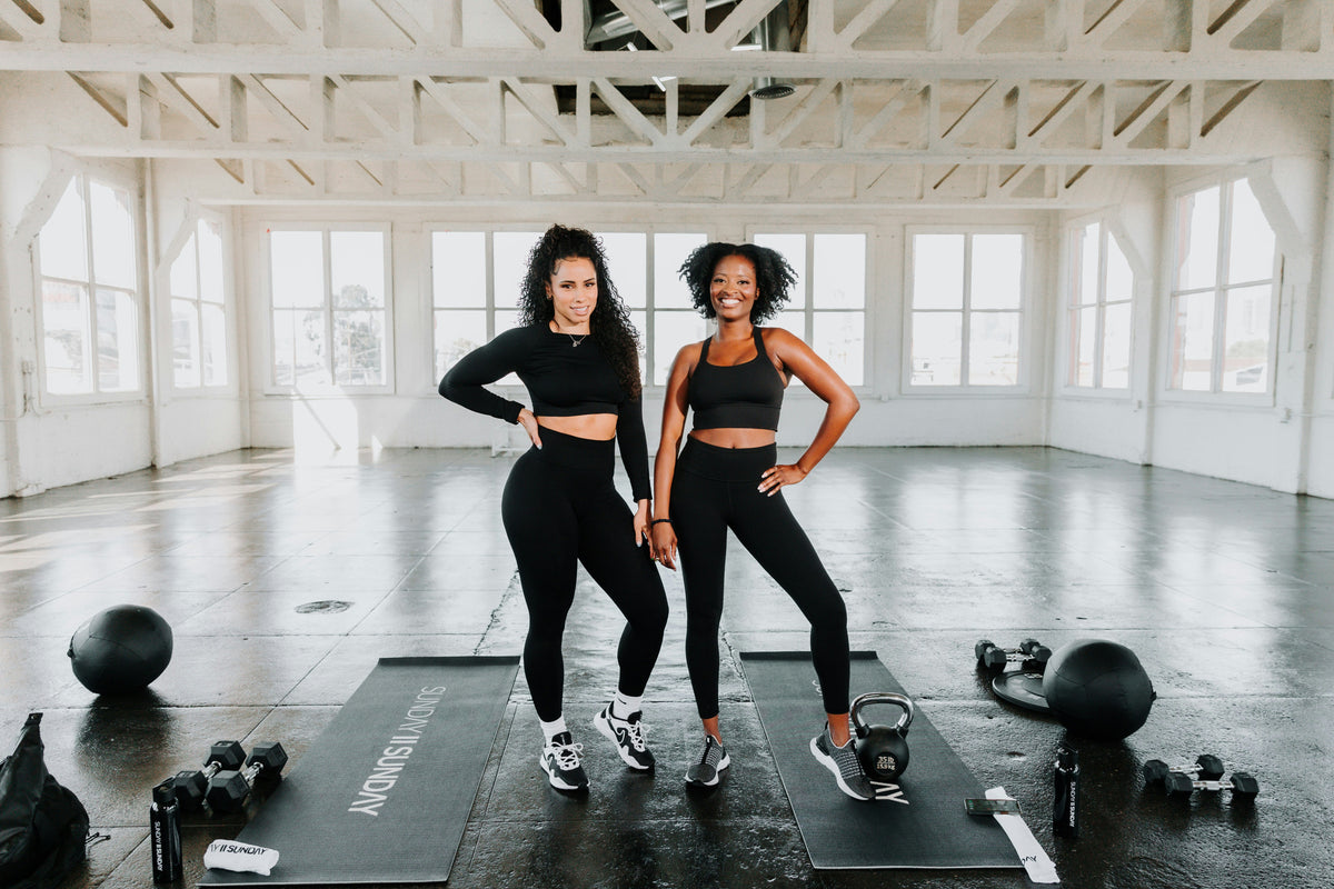 Two women standing together in a bright studio